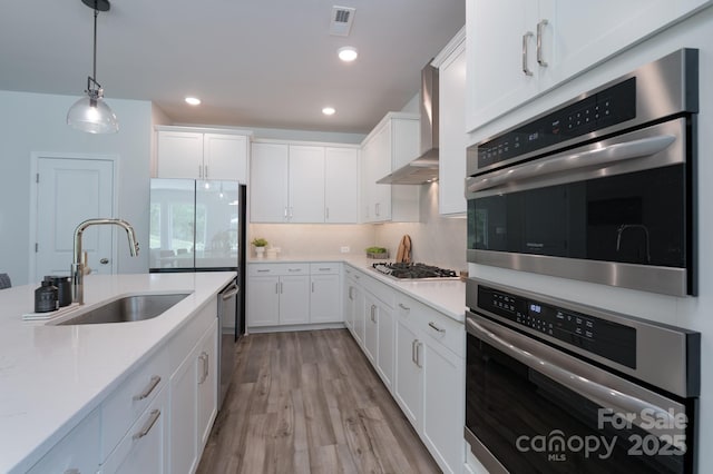 kitchen with white cabinetry, appliances with stainless steel finishes, light countertops, and a sink