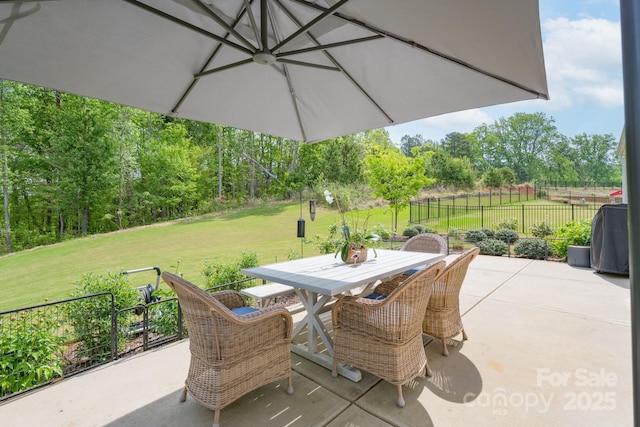 view of patio featuring outdoor dining space and fence