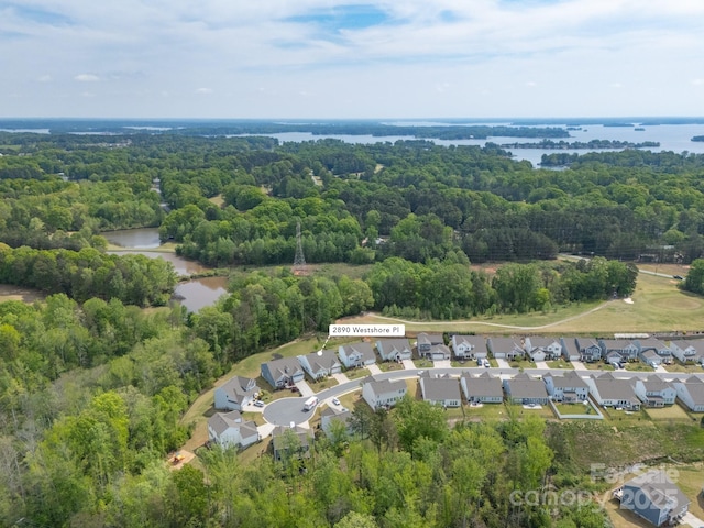bird's eye view with a wooded view, a residential view, and a water view