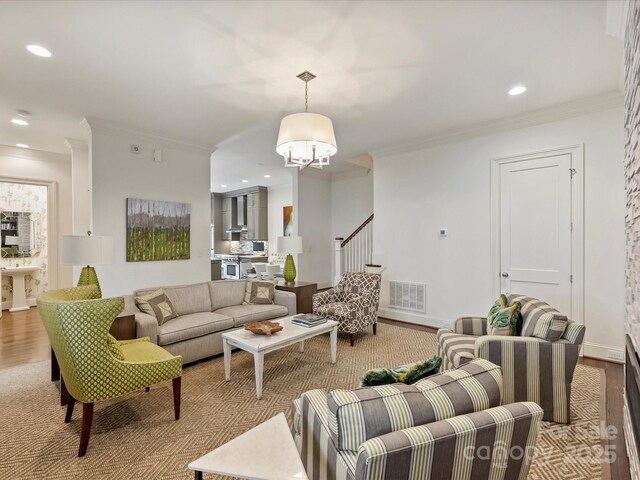 2616 Colton Dr, Charlotte, NC 28211 - living area featuring an inviting chandelier, visible vents, crown molding, and wood finished floors