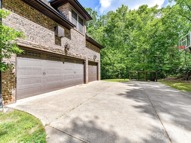 633 Elmhurst Dr, Fort Mill, SC 29715 - view of side of property featuring driveway, a garage, brick siding, and stone siding