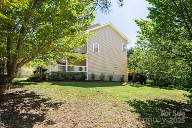 view of home's exterior with a yard and covered porch