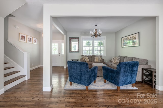 living area with dark wood-style floors, stairway, a chandelier, and baseboards