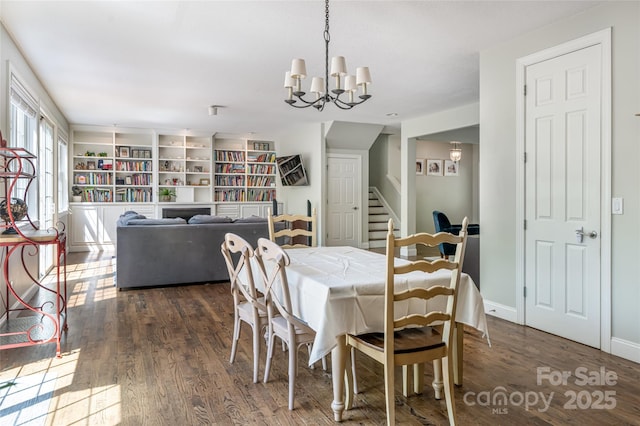 dining room featuring stairway, wood finished floors, and a chandelier