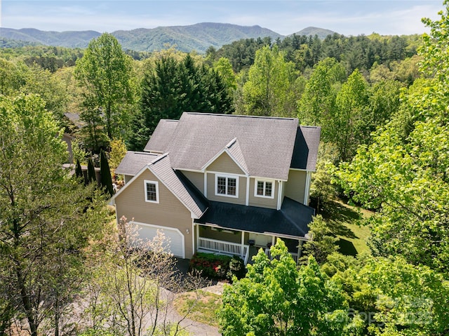 view of subject property with a forest and mountains