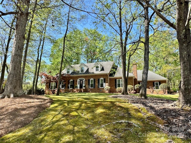 271 Ikerd Dr SE, Concord, NC 28025 - cape cod house with a chimney, a front lawn, and brick siding