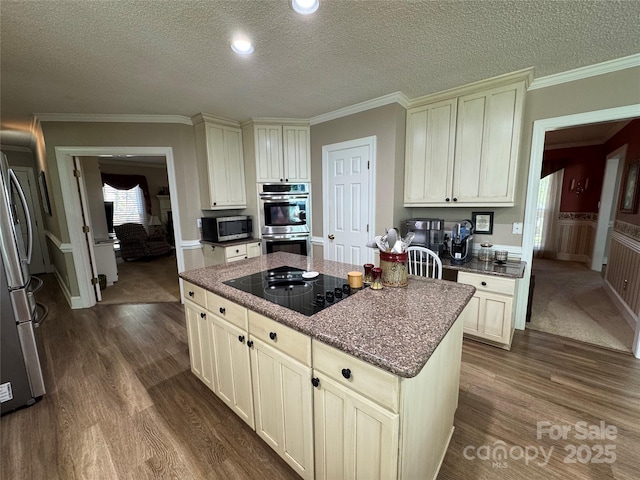 271 Ikerd Dr SE, Concord, NC 28025 - kitchen with dark stone countertops, a textured ceiling, stainless steel appliances, dark wood-type flooring, and a kitchen island