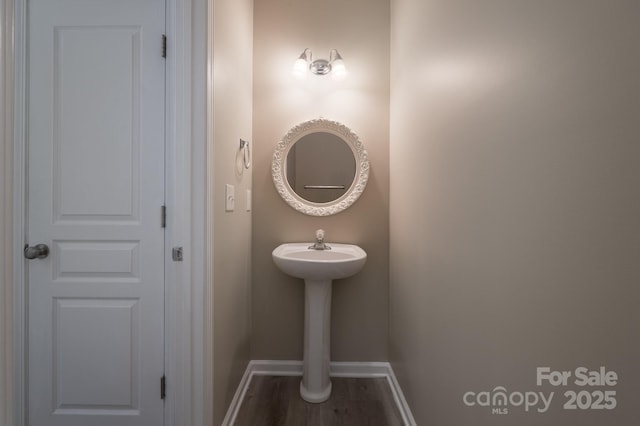 bathroom with baseboards and wood finished floors