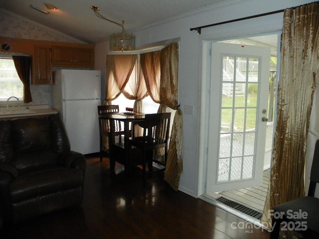 dining area featuring crown molding, visible vents, and vaulted ceiling