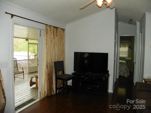 living area with crown molding, a ceiling fan, visible vents, lofted ceiling, and wood finished floors