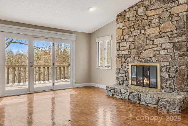 16 Ridgeview Dr, Asheville, NC 28804 - unfurnished living room with lofted ceiling, baseboards, a fireplace, and a textured ceiling