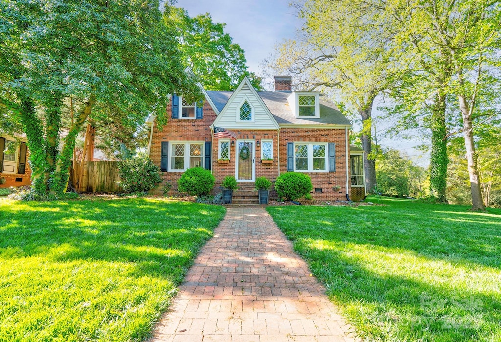 view of front of home featuring a chimney, a front yard, fence, and brick siding