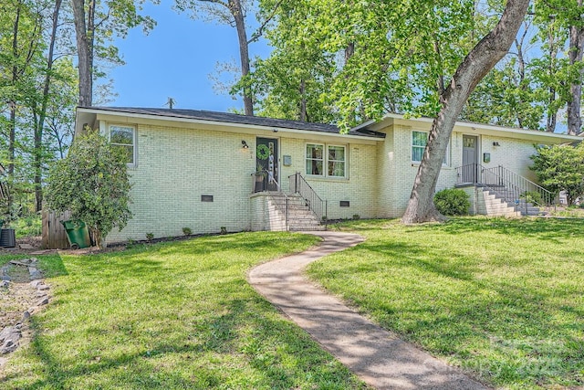 view of front of home with a front lawn, brick siding, and crawl space
