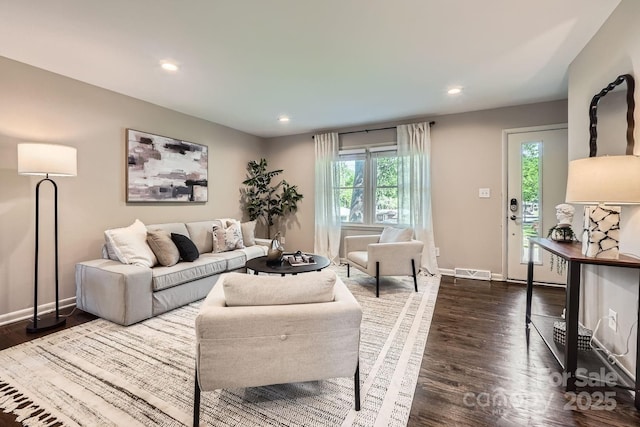 living area featuring recessed lighting, baseboards, dark wood-type flooring, and plenty of natural light