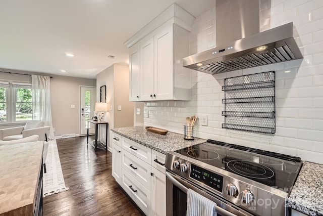 kitchen with wall chimney range hood, white cabinetry, decorative backsplash, stainless steel electric range, and dark wood-style flooring