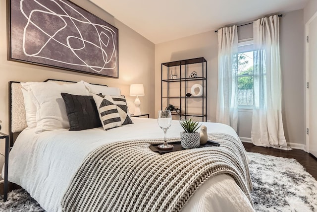 bedroom with baseboards and wood finished floors