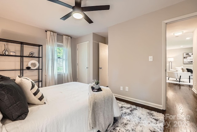 bedroom with ceiling fan, baseboards, and wood finished floors