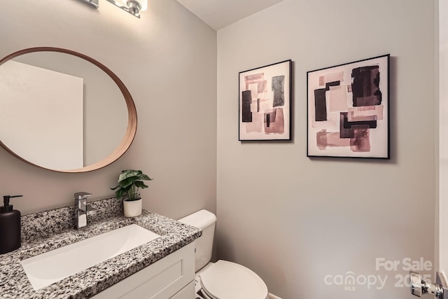 half bath featuring toilet and vanity