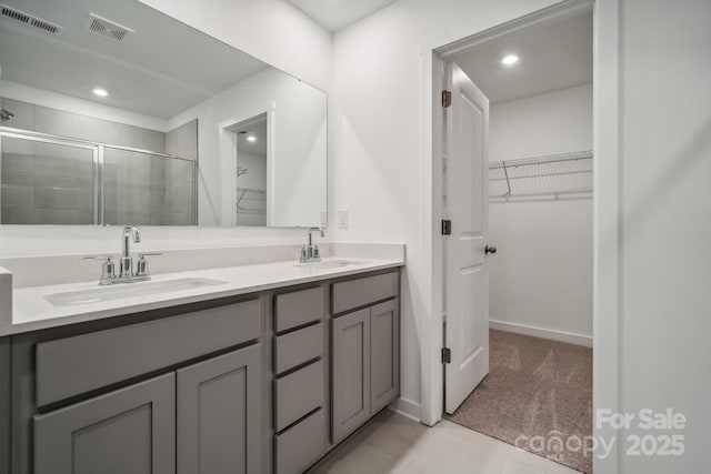 bathroom with a shower stall, visible vents, and a sink