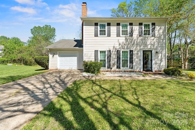 colonial home featuring driveway, a front lawn, a chimney, and an attached garage