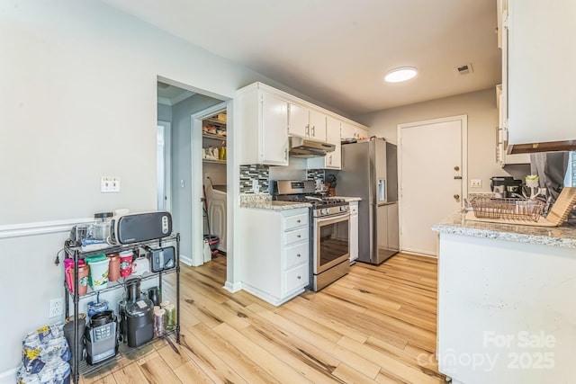 kitchen with light wood-type flooring, white cabinets, under cabinet range hood, visible vents, and stainless steel appliances