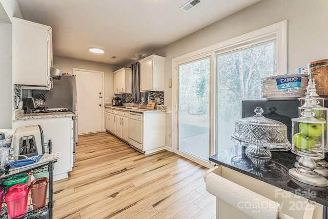 kitchen featuring light wood-style floors, white cabinetry, visible vents, dishwasher, and light countertops