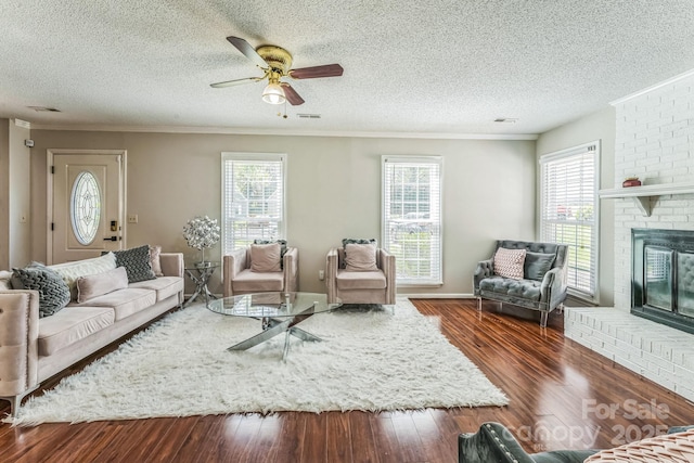 living area featuring a textured ceiling, wood finished floors, and ceiling fan