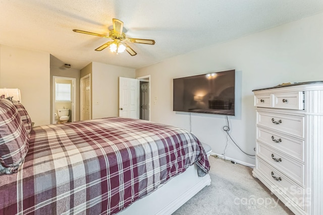 bedroom featuring ceiling fan, connected bathroom, and light carpet