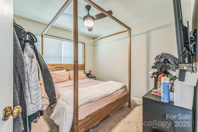 carpeted bedroom featuring a textured ceiling and a ceiling fan