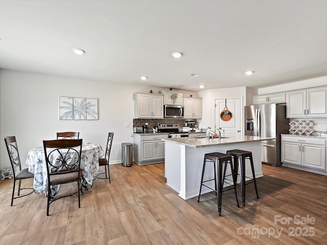 479 Daniel Dr, Lexington, NC 27295 - kitchen with an island with sink, a kitchen bar, light wood-type flooring, appliances with stainless steel finishes, and a sink