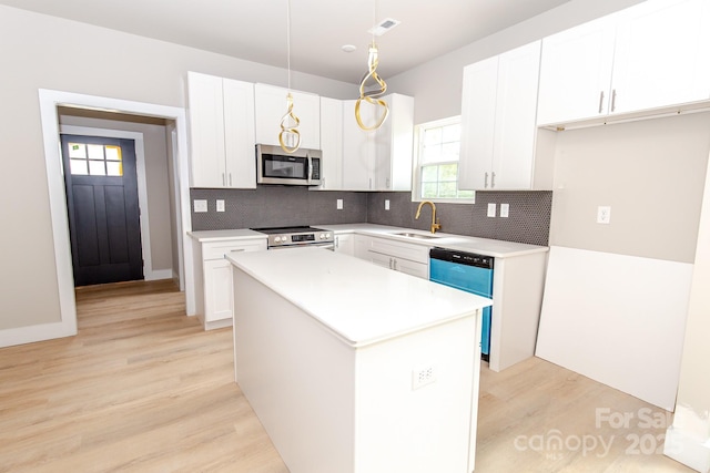 2350 14th Street Ct NE, Hickory, NC 28601 - kitchen featuring stainless steel appliances, decorative backsplash, light wood-style floors, and white cabinetry