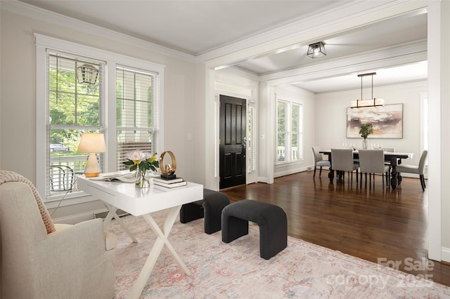 dining area featuring wood finished floors, crown molding, a chandelier, and baseboards