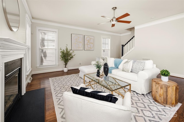living room with crown molding, ceiling fan, healthy amount of natural light, wood finished floors, and baseboards