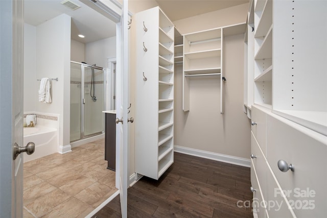 walk in closet with wood finished floors