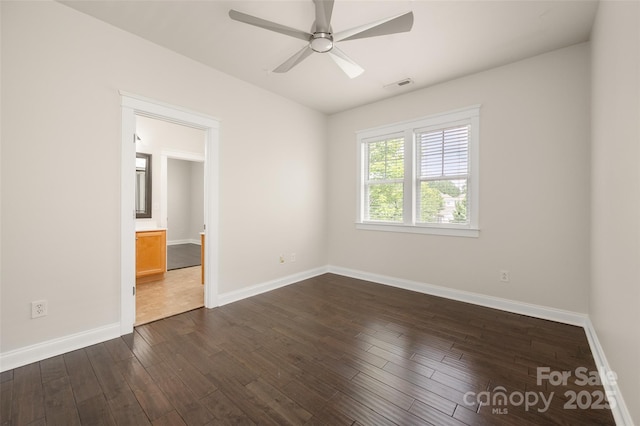 unfurnished room with a ceiling fan, dark wood-type flooring, and baseboards
