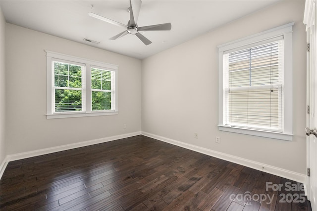 empty room featuring dark wood-style floors, baseboards, and ceiling fan