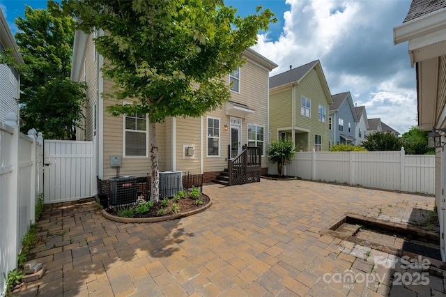 view of patio with a fenced backyard, central AC unit, and a residential view