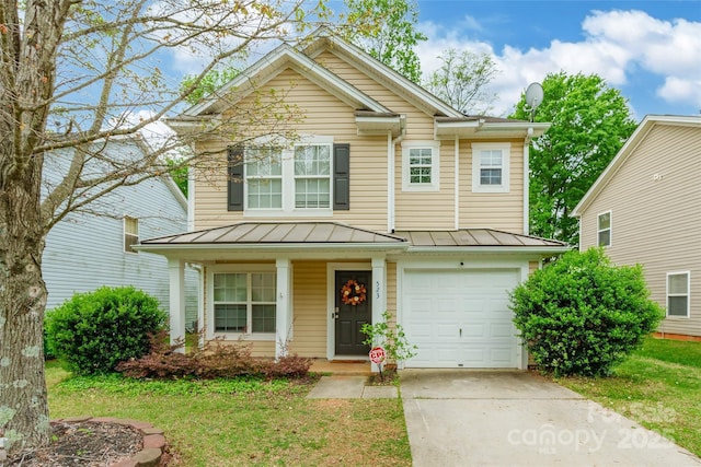 traditional-style house featuring concrete driveway, a garage, a porch, a standing seam roof, and metal roof