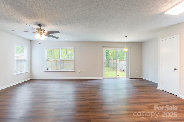 unfurnished room with a textured ceiling, ceiling fan, and dark wood finished floors