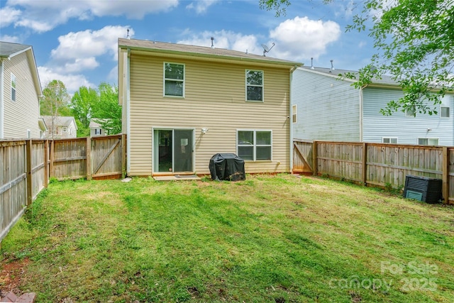 rear view of house featuring a fenced backyard and a lawn