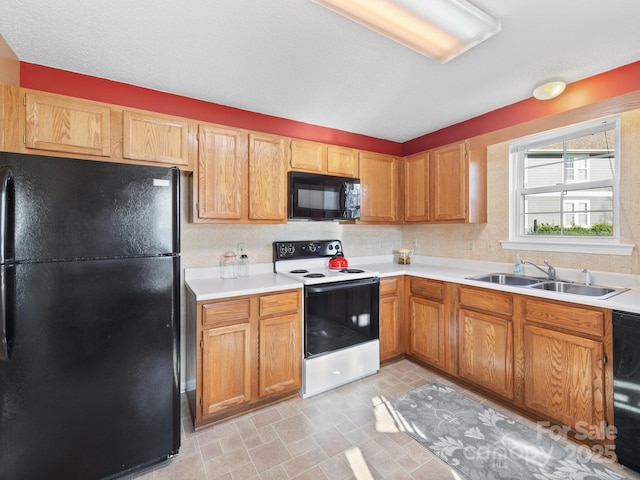 kitchen with light countertops, a sink, and black appliances