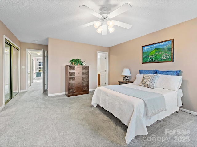 bedroom featuring carpet flooring, baseboards, a textured ceiling, and ceiling fan