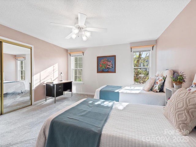 bedroom featuring carpet, a textured ceiling, baseboards, and ceiling fan