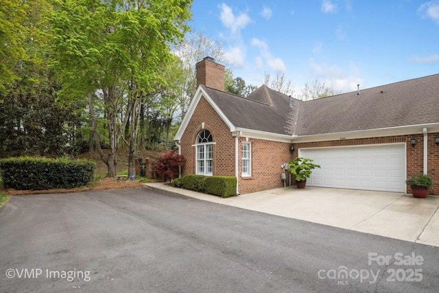 7444 Hurstbourne Green Dr, Charlotte, NC 28277 - view of front of home featuring a chimney, driveway, an attached garage, brick siding, and a shingled roof