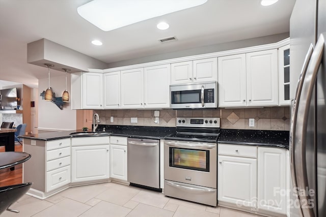 7444 Hurstbourne Green Dr, Charlotte, NC 28277 - kitchen featuring visible vents, white cabinets, a sink, a peninsula, and stainless steel appliances