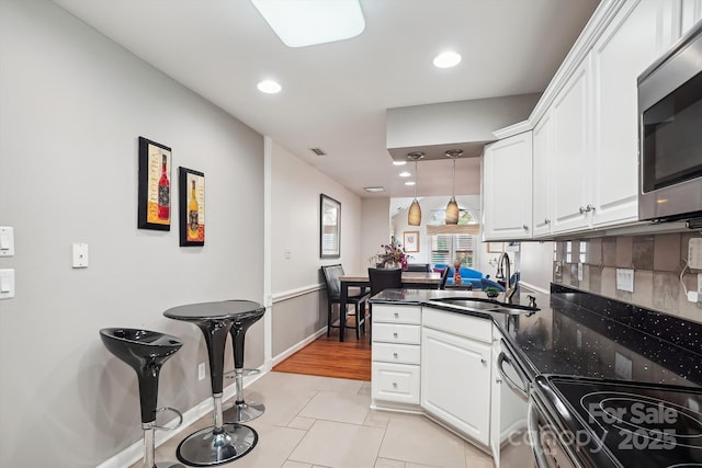 7444 Hurstbourne Green Dr, Charlotte, NC 28277 - kitchen with recessed lighting, a peninsula, white cabinetry, stainless steel appliances, and a sink