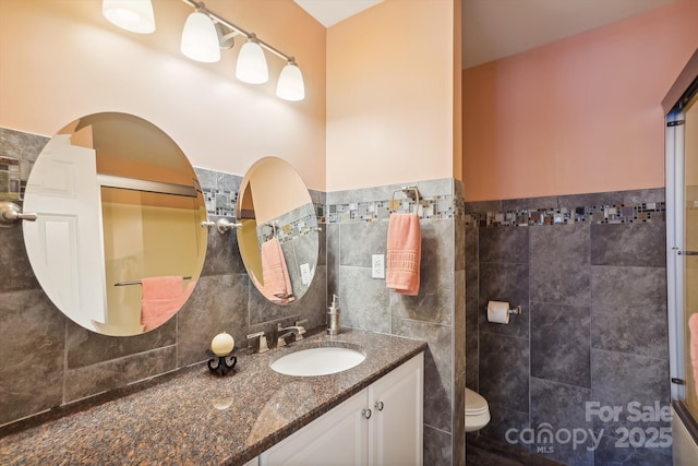 7444 Hurstbourne Green Dr, Charlotte, NC 28277 - full bathroom featuring toilet, vanity, wainscoting, and tile walls