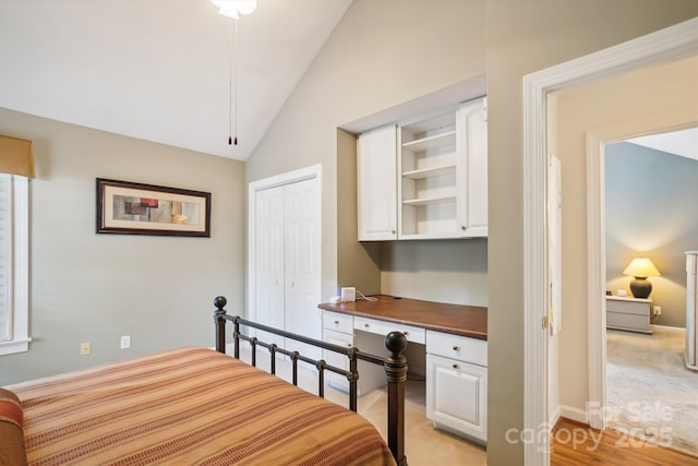 7444 Hurstbourne Green Dr, Charlotte, NC 28277 - bedroom featuring light wood-style flooring, a closet, vaulted ceiling, built in desk, and baseboards