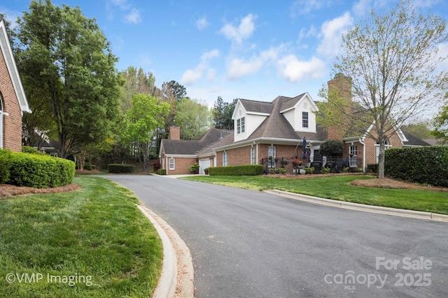 7444 Hurstbourne Green Dr, Charlotte, NC 28277 - exterior space featuring aphalt driveway, a lawn, brick siding, an attached garage, and a chimney