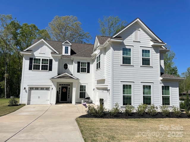 view of front of property with a shingled roof, concrete driveway, a front yard, and a garage